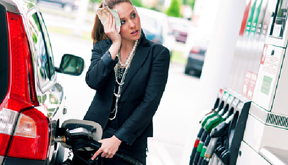 Frau steht neben der Zapfsäule und tankt ihr Auto voll. © bertys30, fotolia.com
