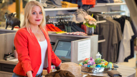 Verkäuferin steht bei Kassa