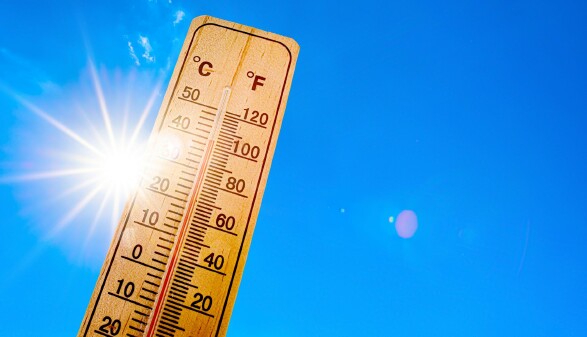 Sommerhintergrund - blauer Himmel mit strahlender Sonne und Thermometer