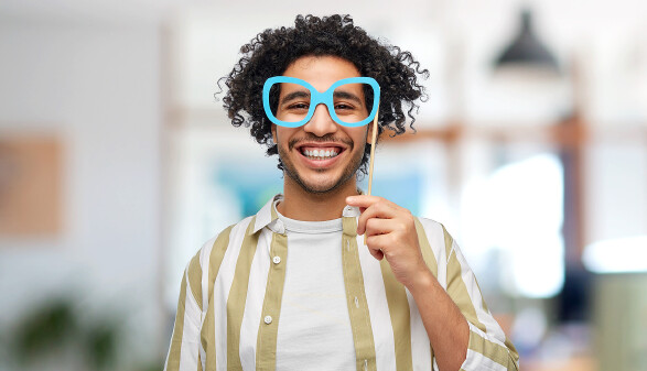 Junger Mann mit Faschingsmaske im B&uuml;ro