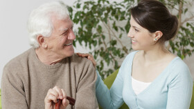 Pflegebedürftiger älterer Mann mit seiner jungen Betreuerin