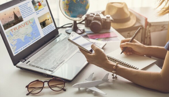 Junge Frau beim Urlaub buchen am PC