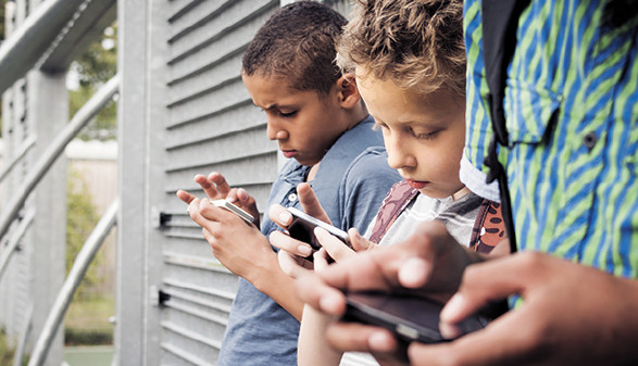 Kinder stehen nebeneinander und schauen in ihr Smartphone © bramgino, Fotolia